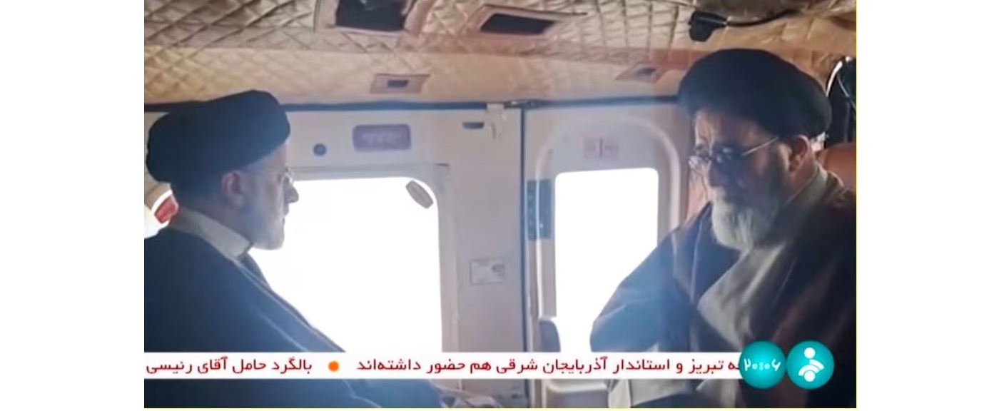 رئيسي، على اليسار، مع عضو مجهول من وفده على متن المروحية بحسب وكالة فرانس برس